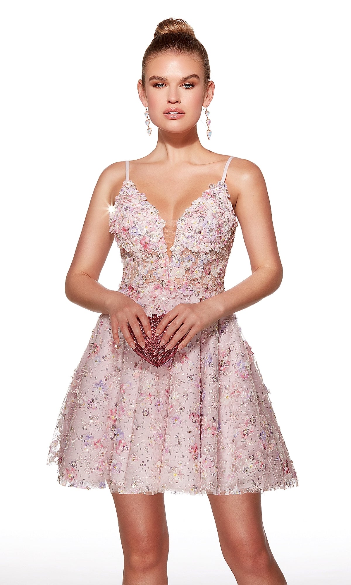 A young woman wears the Alyce 30017 short homecoming dress, a sleeveless light pink style with floral and rhinestone embellishments and a deep V-neckline, holding a small clutch against a plain white background.